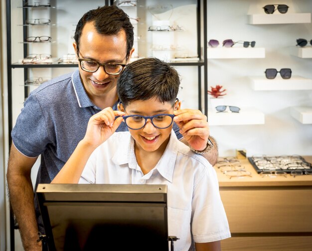 happy-indian-father-cute-son-choosing-eyeglasses-optics-storexa_615977-236