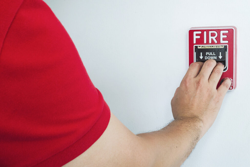 man-is-reaching-his-hand-push-fire-alarm-hand-station-1024x683
