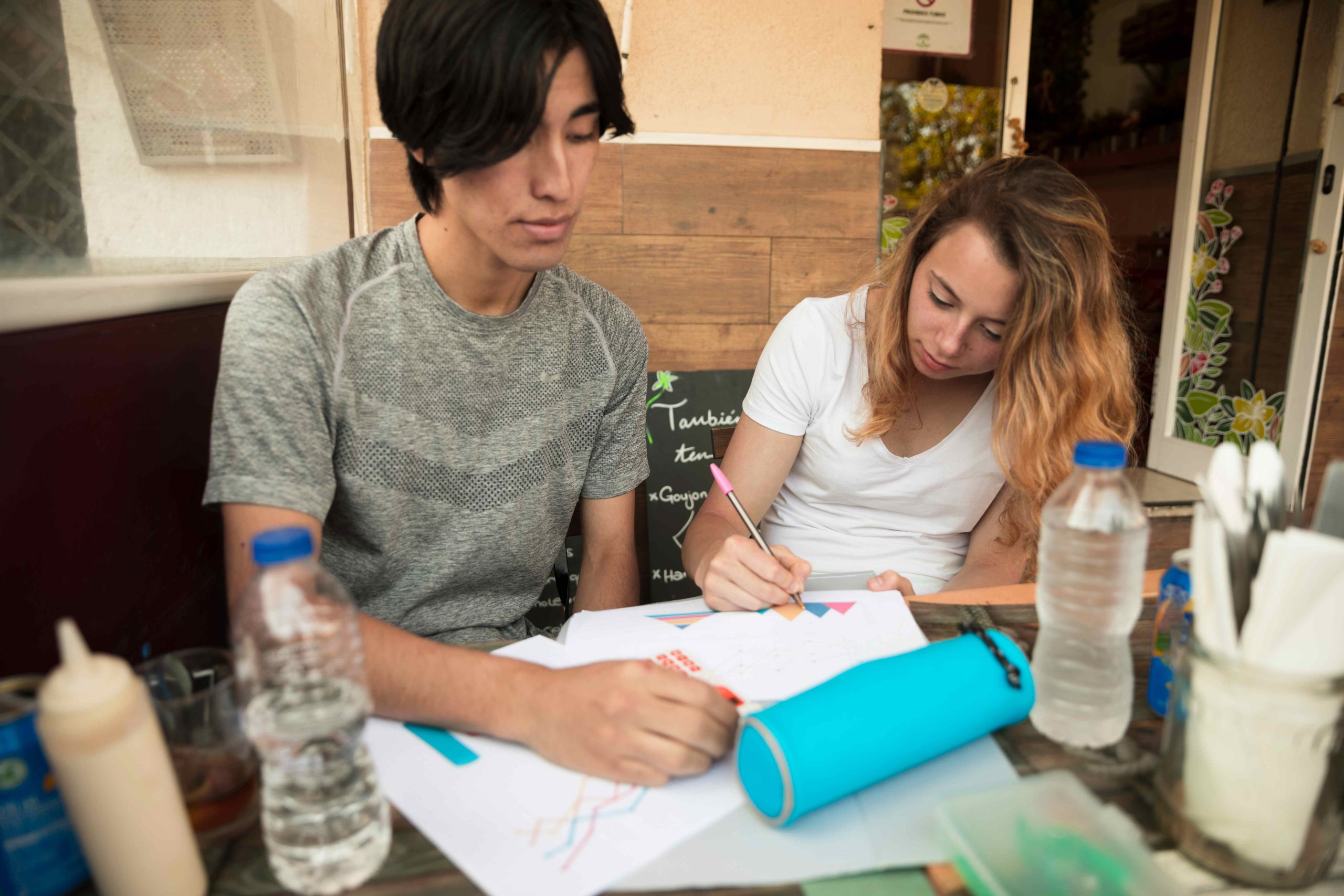 multiracial-young-couple-painting-papers-table-compressed