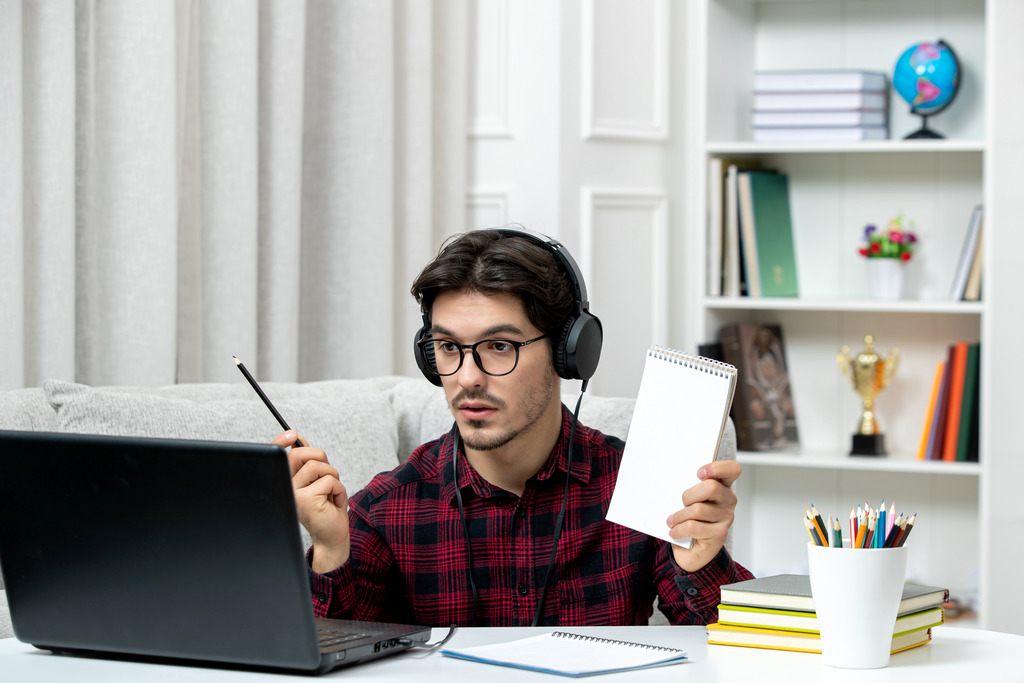 u8721-student-online-cute-guy-checked-shirt-with-glasses-studying-computer-holding-pen-notebook-1
